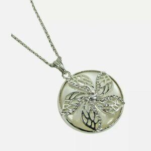 Flower round pendant with crystals set into it and on top of a white setting